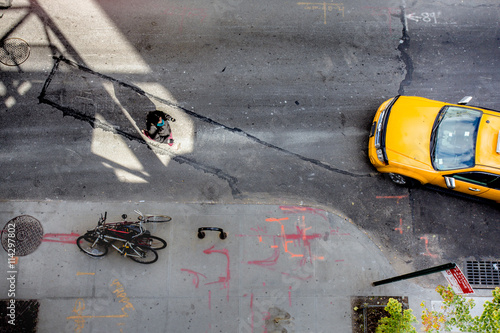 View of from above of urban street in New York City Manhattan with yellow taxi cab and pedestrian
