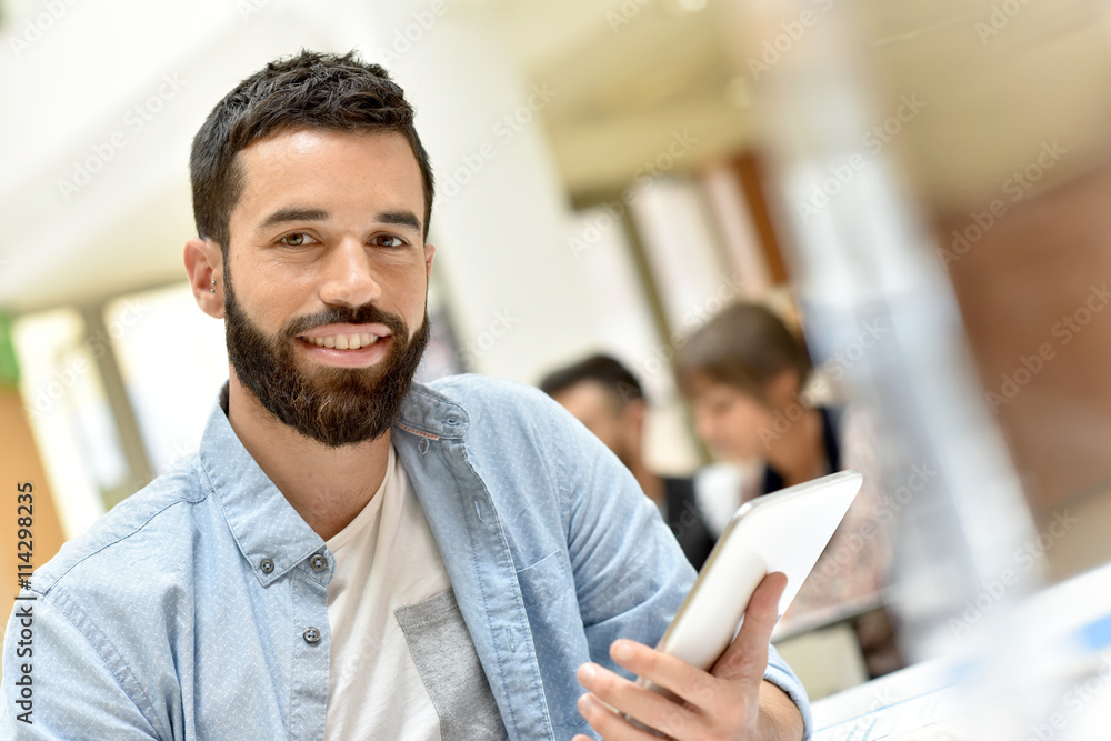 Bearded trendy guy in office working on tablet Bearded trendy guy in office working on tablet