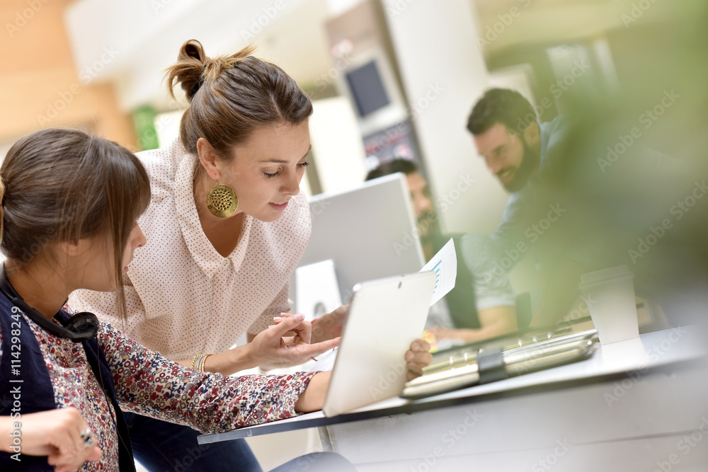 Young women in office working on digital tablet Young women in office working on digital tablet