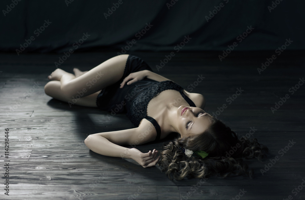 Sexy dressed woman laying down on a dark wooden floor foto de Stock | Adobe  Stock