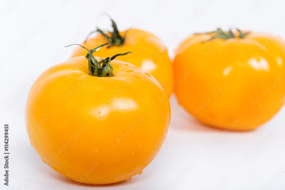 Fresh yellow tomatoes with green leaves. Yellow tomatoes isolated on white background. Fresh yellow tomatoes with green leaves. Yellow tomatoes isolated on white background.