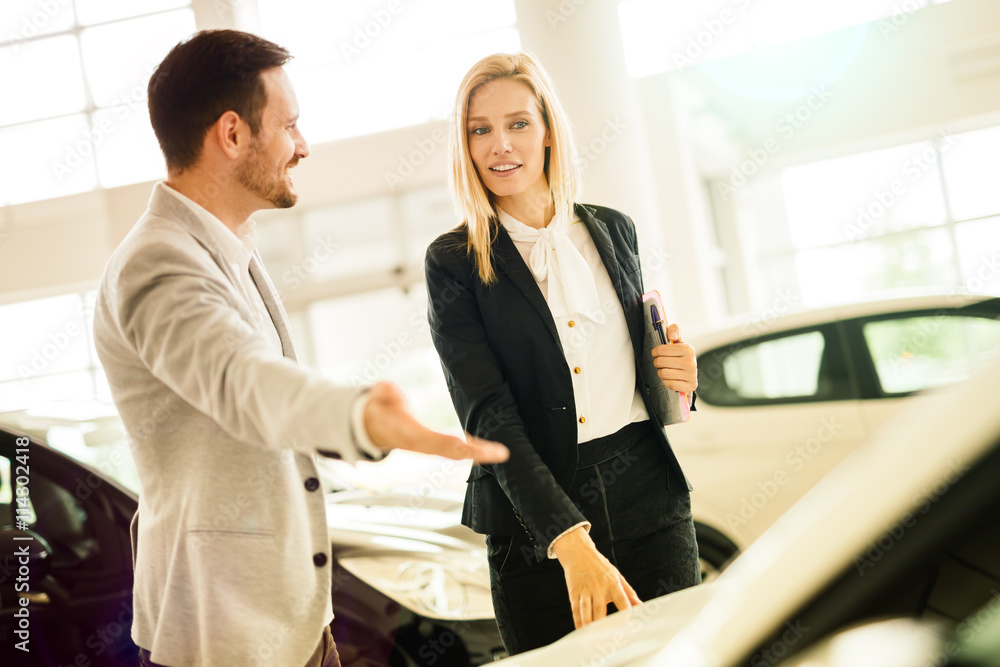 Salesperson showing vehicle to potential customer