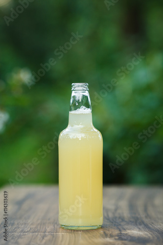 homemade lemonade in glass bottle on bokeh background