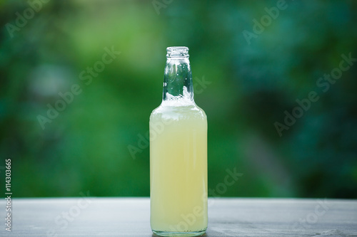 homemade lemonade in glass bottle on bokeh background