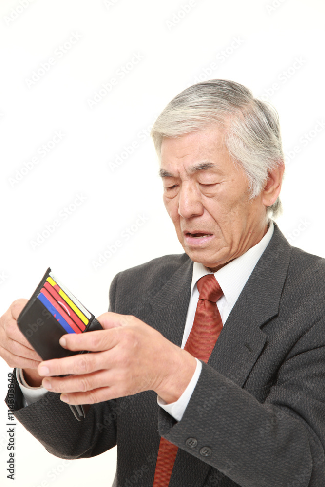 からっぽの財布を見て途方に暮れる年輩のビジネスマン からっぽの財布を見て途方に暮れる年輩のビジネスマン