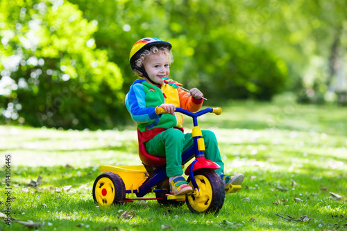Little boy on colorful tricycle photo