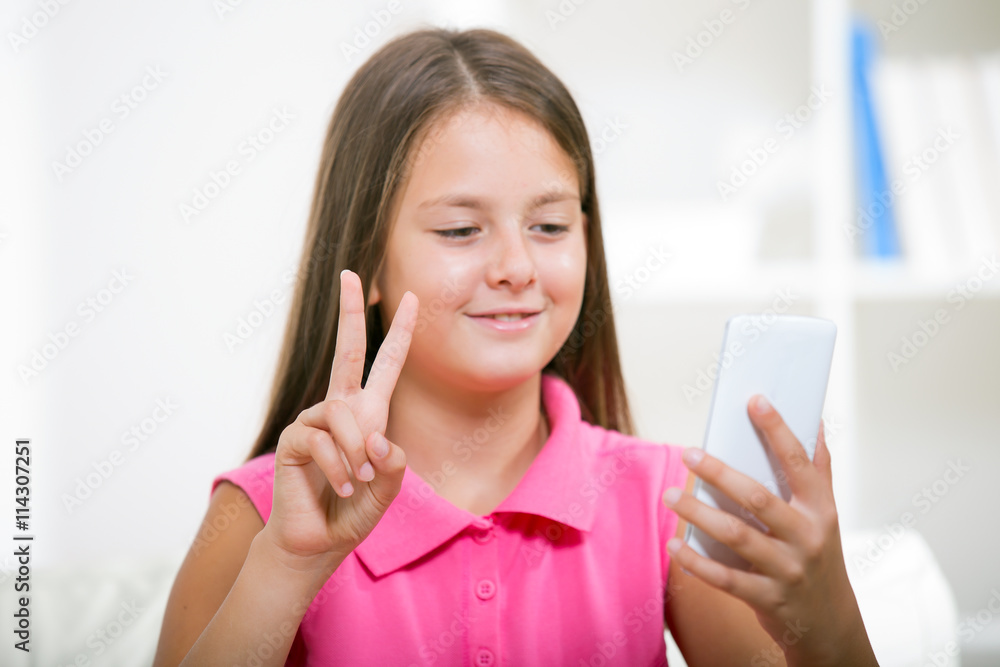 Smiling deaf girl talking using sign language on the smartphone' Smiling deaf girl talking using sign language on the smartphone'