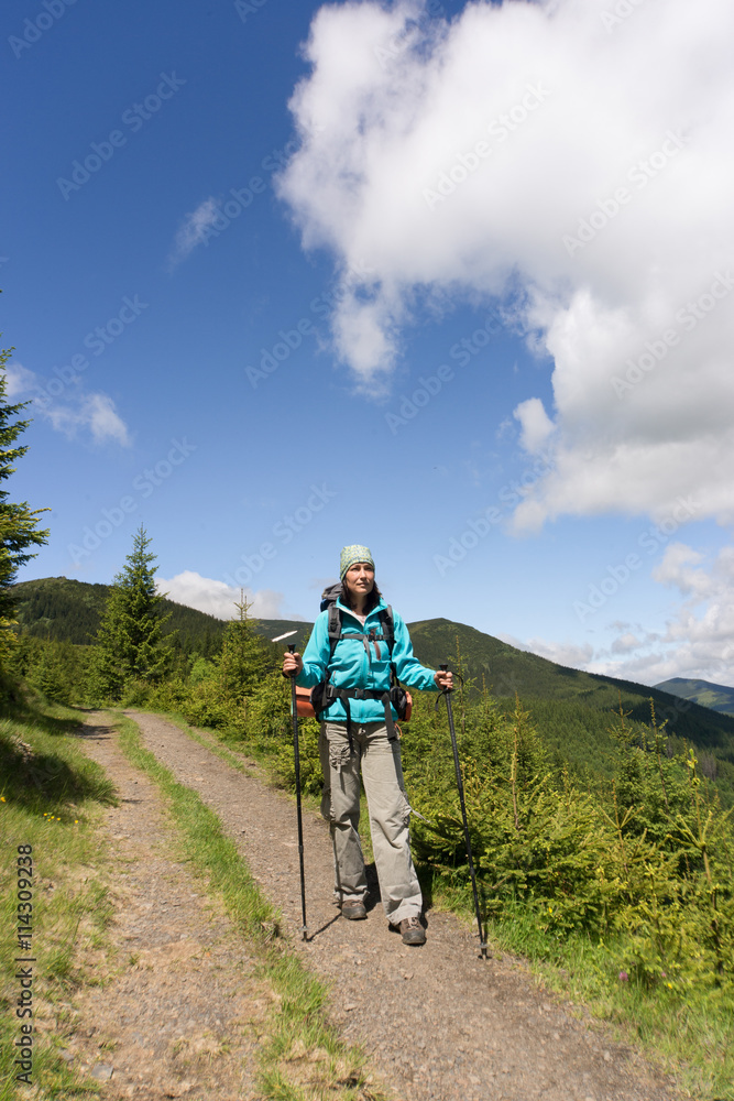 Hiking in the mountains with a backpack on a sunny summer day