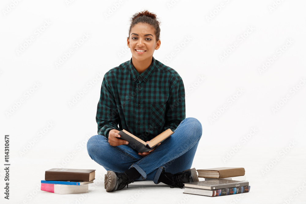 Portrait of young african girl with books over white background. Portrait of young african girl with books over white background.