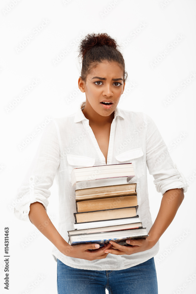 Portrait of young african girl with books over white background. Portrait of young african girl with books over white background.
