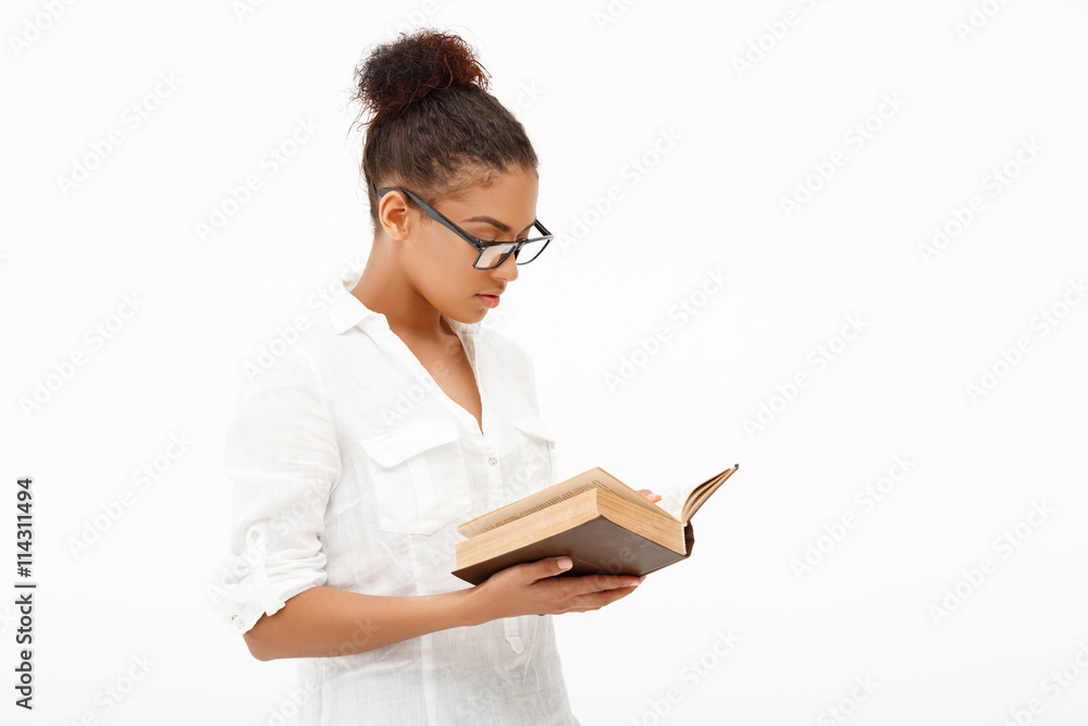 Portrait of young african girl with book over white background. Portrait of young african girl with book over white background.