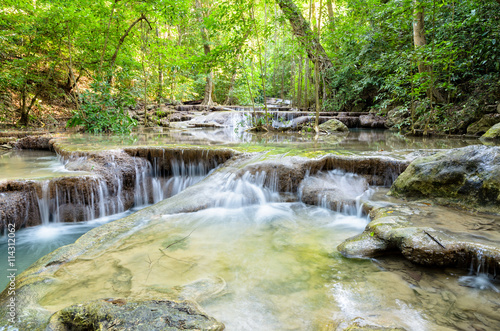 Fototapeta Naklejka Na Ścianę i Meble -  Beautiful waterfall and tropical forests at Erawan National Park is a famous tourist attraction in Kanchanaburi Province, Thailand
