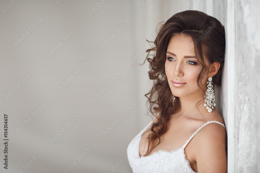 Studio portrait of beautiful bride with perfect hairstyle and ma