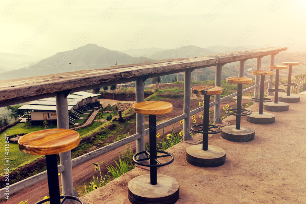 Lonely empty chairs on a deck at sunrise ready for treveler to Lonely empty chairs on a deck at sunrise ready for treveler to