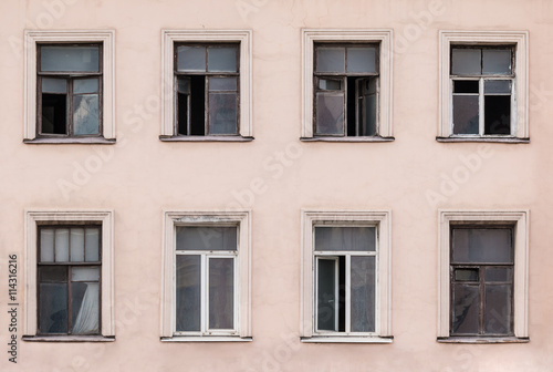 Several windows in a row on facade of urban apartment building front view, St. Petersburg, Russia.