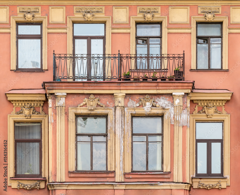 Obraz premium Several windows in a row and balcony on facade of urban apartment building front view, St. Petersburg, Russia.