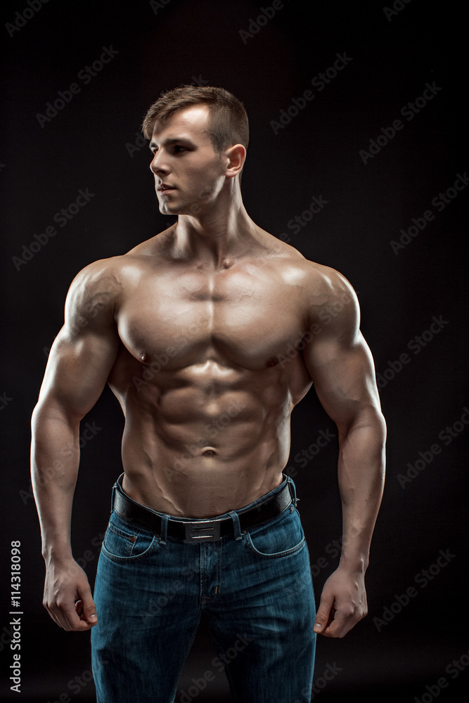 Muscular bodybuilder guy doing posing over black background Muscular bodybuilder guy doing posing over black background