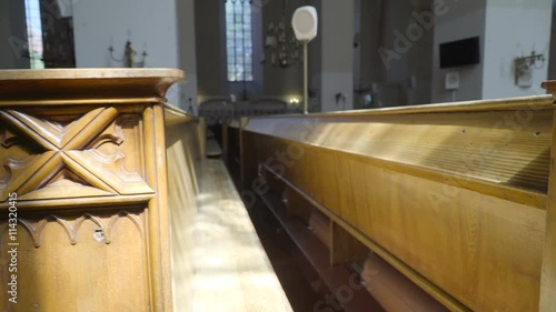 Closer look of the benches and chairs inside the church with the sculptures in the side of the chair photo