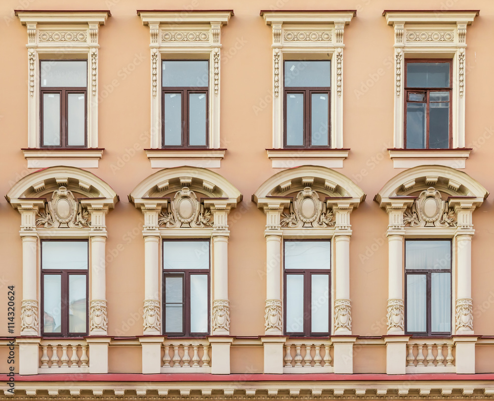 Several windows in a row on facade of urban apartment building front view, St. Petersburg, Russia.