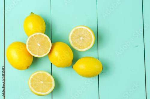 Lemons scattered on a blue wooden background.