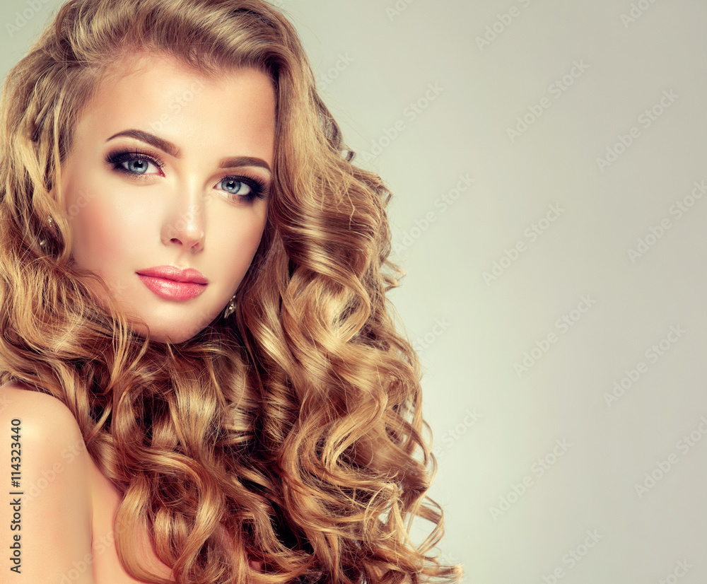 Beautiful girl with long wavy hair . Blonde model with curly hairstyle .  Stock Photo | Adobe Stock