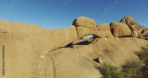 4K aerial shot flying through the granite arch of the Spitzkoppe mountains photo