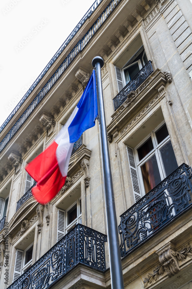 French flag against street buildings