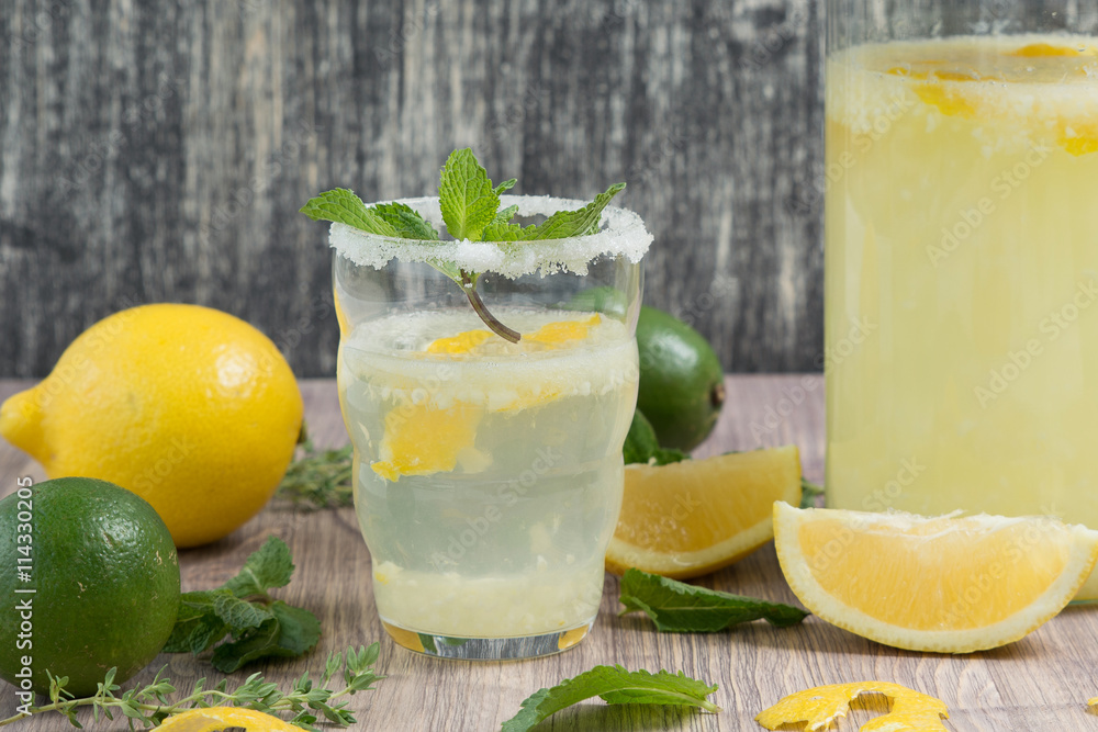 jug and glass of lemonade whith mint on wooden table. Citrus lemonade, summer drink jug and glass of lemonade whith mint on wooden table. Citrus lemonade, summer drink
