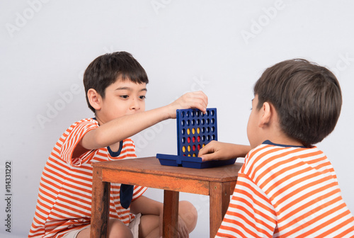 Little boy playing connect four game soft focus at eye contact photo