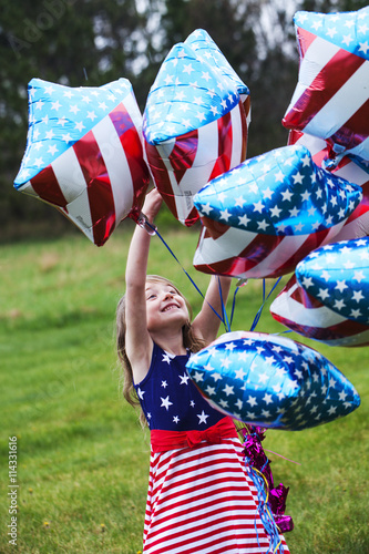 Cheerful American  girl holding balloons outside. 4th of July. Independence day. 
