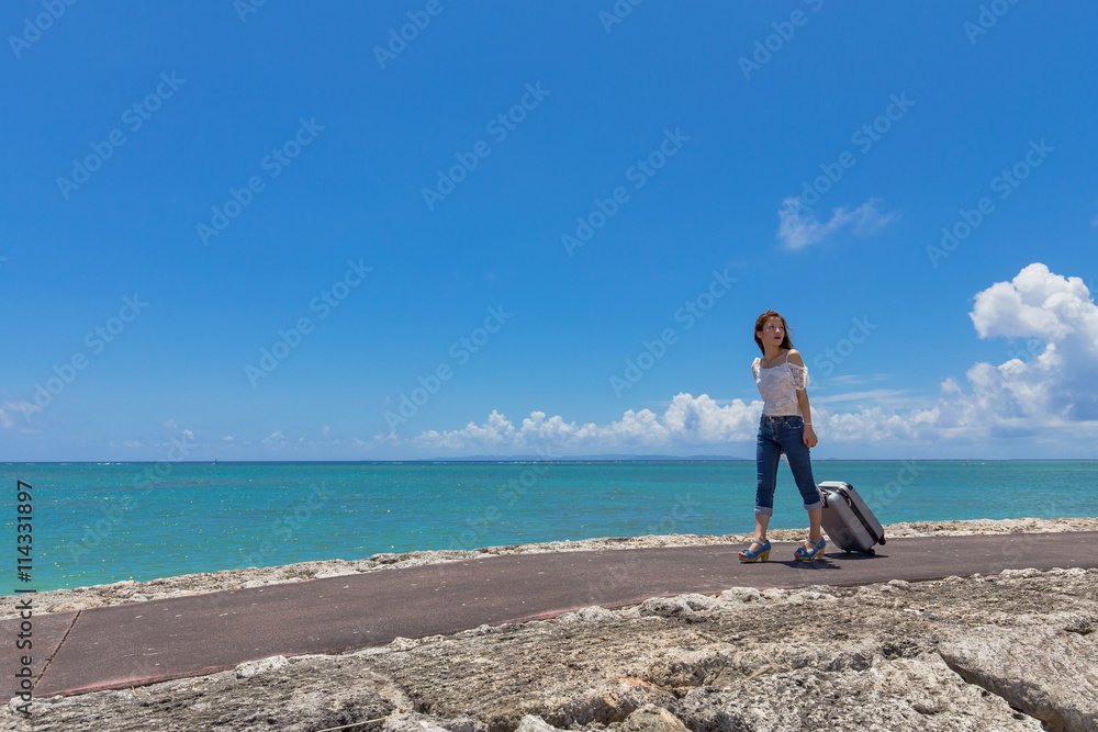 沖縄の海と旅をする女性