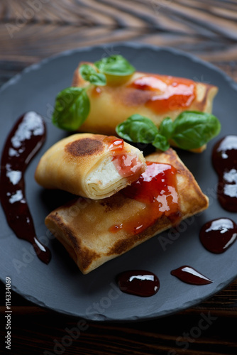 Closeup of pancakes with cottage cheese stuffing served with jam