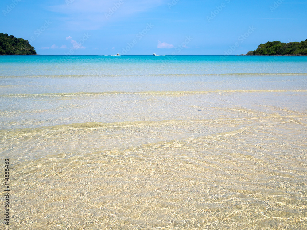 Background of transparent crystal blue sea water surface ripple over sand with sun reflection in summer. Water background. Ocean water texture. Background of transparent crystal blue sea water surface ripple over sand with sun reflection in summer. Water background. Ocean water texture.