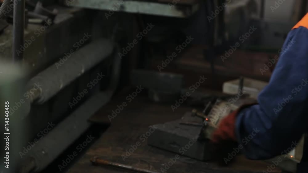 Welder in a protective helmet welded metal parts. Welder in a protective helmet welded metal parts.