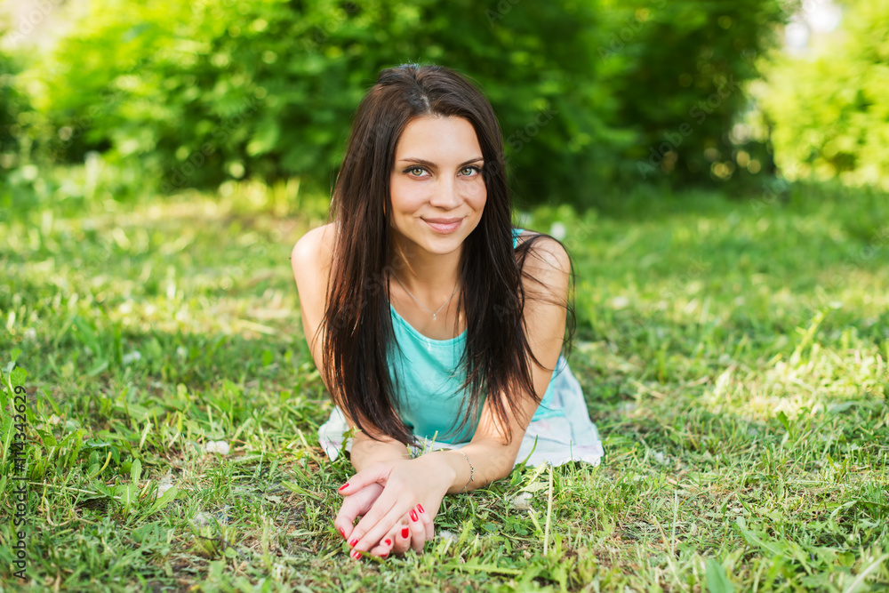 Beautiful woman relaxing outdoors on grass looking happy and smiling. Beautiful woman relaxing outdoors on grass looking happy and smiling.