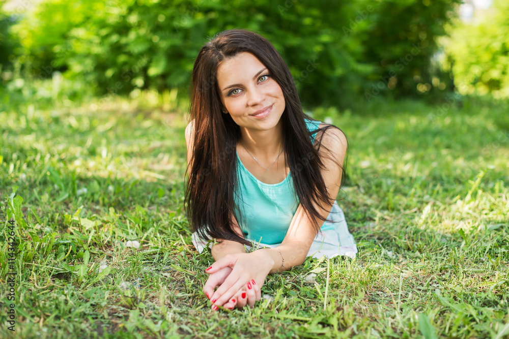 Beautiful woman relaxing outdoors on grass looking happy and smiling. Beautiful woman relaxing outdoors on grass looking happy and smiling.