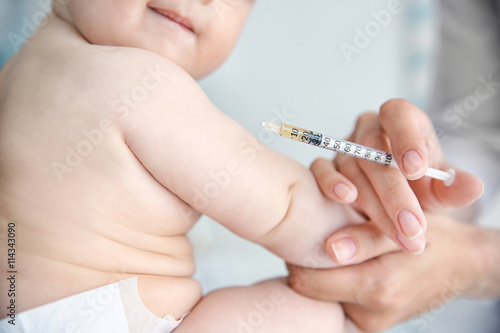 Professional pediatrician vaccinating baby  close up