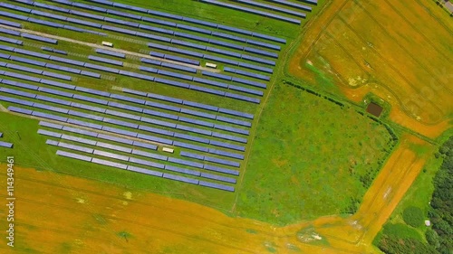 Camera flight over a solar power plant in agricultural landscape. Industrial background on renewable resources theme. Industry of power and fuel generation in European Union. photo