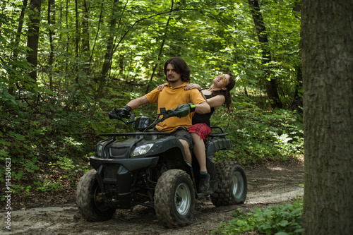man and woman riding on an ATV