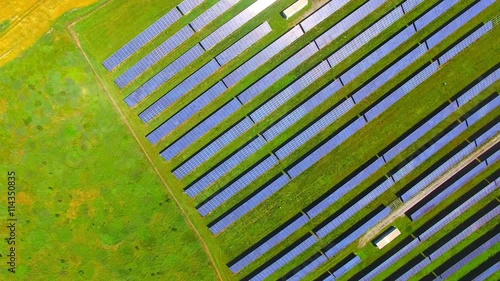 Camera flight over a solar power plant in agricultural landscape. Industrial background on renewable resources theme. Industry of power and fuel generation in European Union. photo