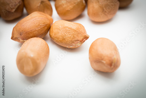 Close up of processed peanuts on white background in dark mood.