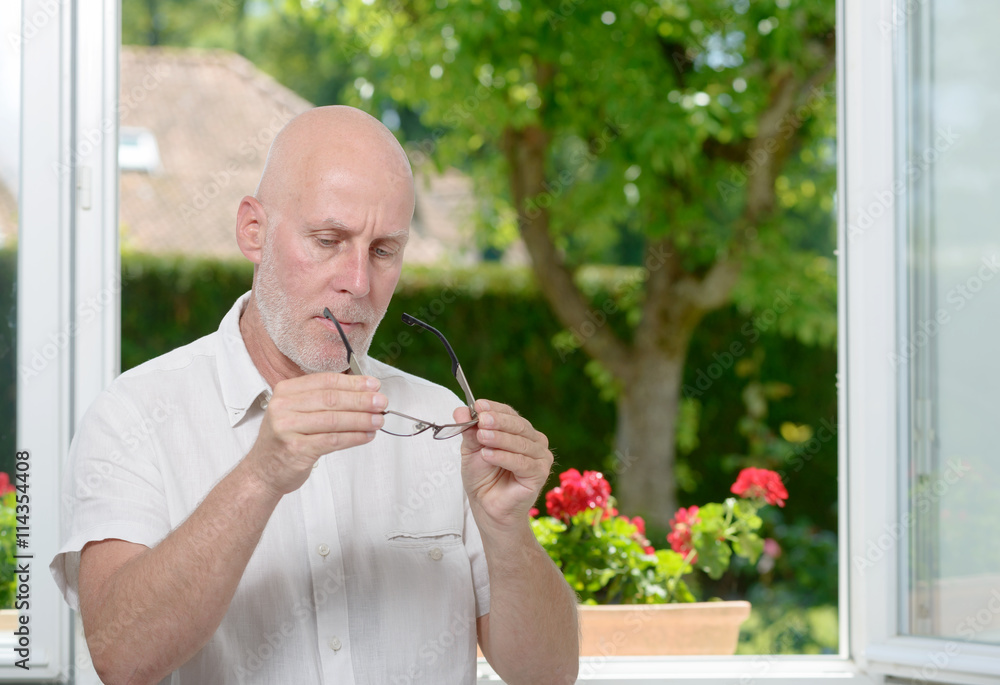mature man with glasses near a window mature man with glasses near a window