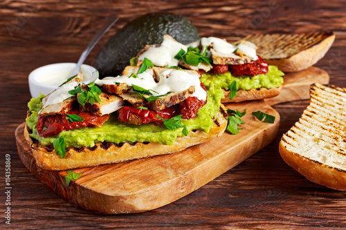 Avocado Sandwich with sunshine dried tomatoes, roasted pork and sauce herbs
