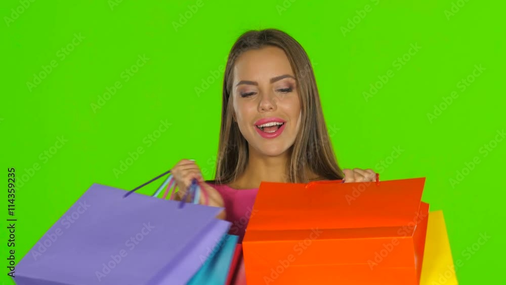 Woman holding shopping bags and smiling. Green screen. Close up Woman holding shopping bags and smiling. Green screen. Close up