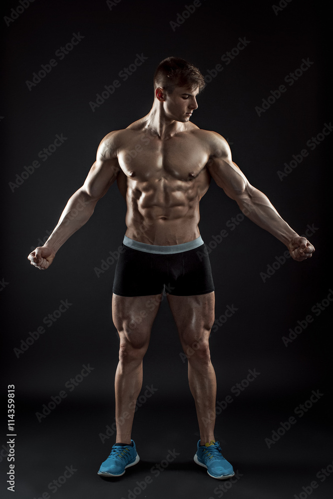 Muscular bodybuilder guy doing posing over black background Muscular bodybuilder guy doing posing over black background