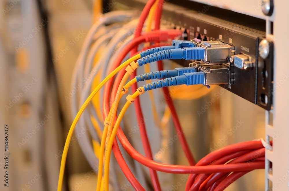 Fiber Optic cables connected to an optic ports and UTP Network cables connected to ethernet ports. Fiber Optic cables connected to an optic ports and UTP Network cables connected to ethernet ports.