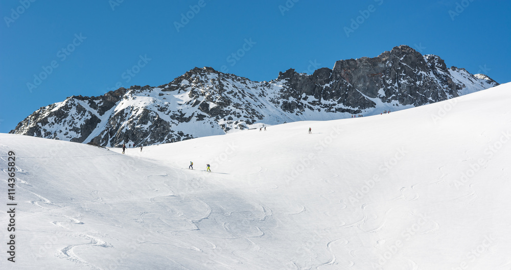 Snow covered slope with ski tracks.