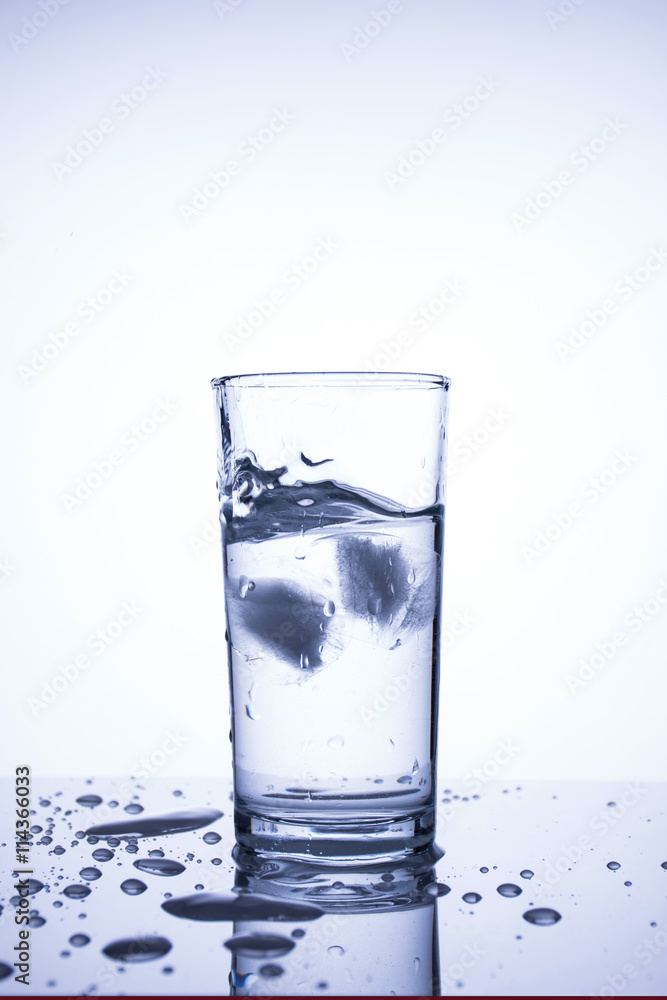 Cubes of natural ice splashing into glass with clean water Cubes of natural ice splashing into glass with clean water