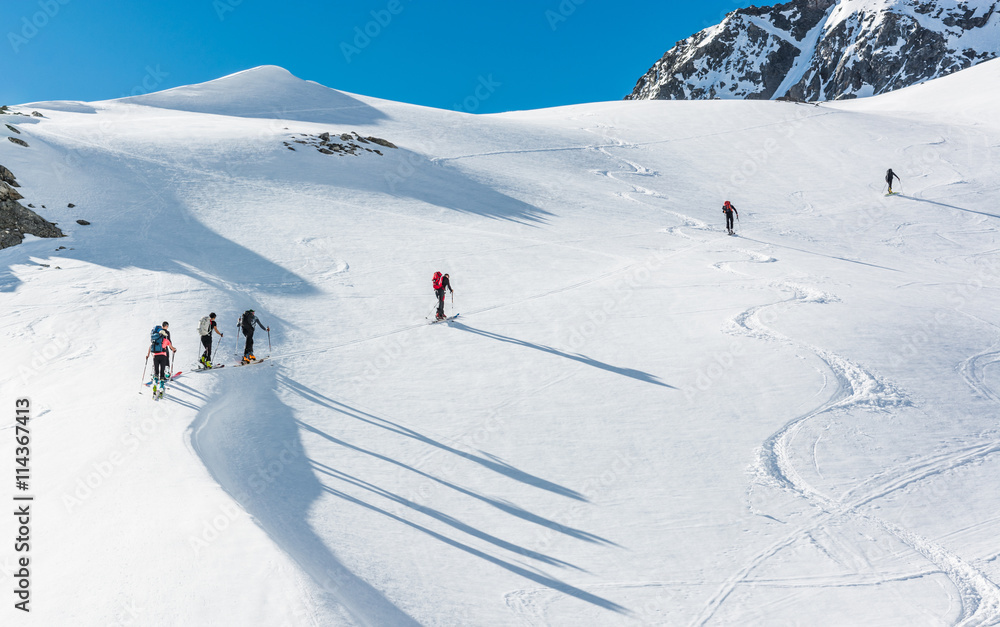 Skiers ascending a mountain slope.