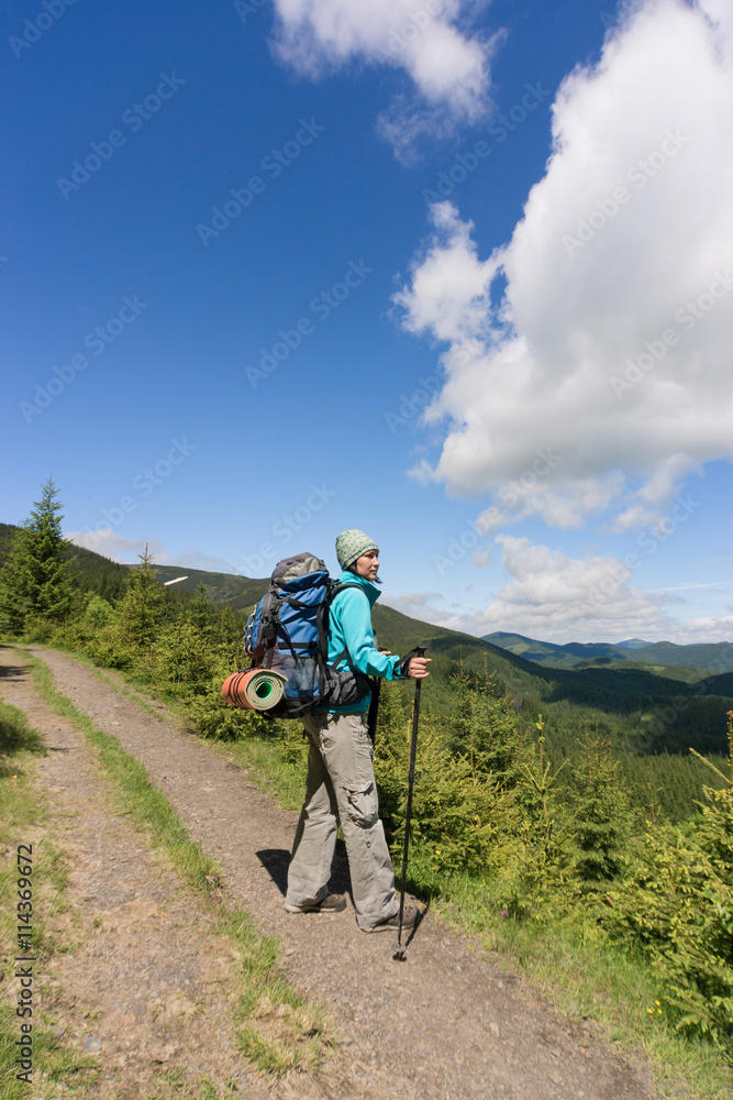 Hiking in the mountains with a backpack on a sunny summer day